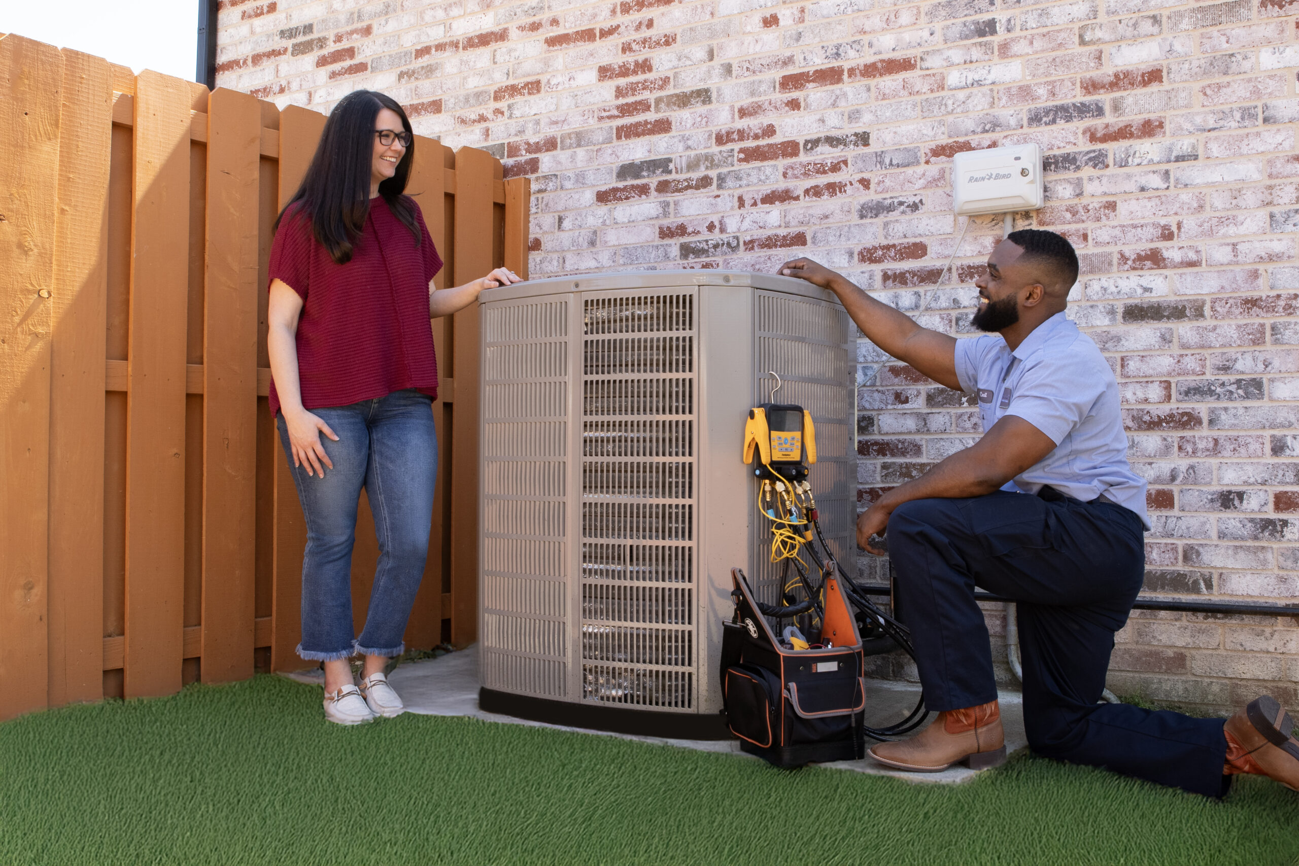 Technicians servicing AC unit outdoors
