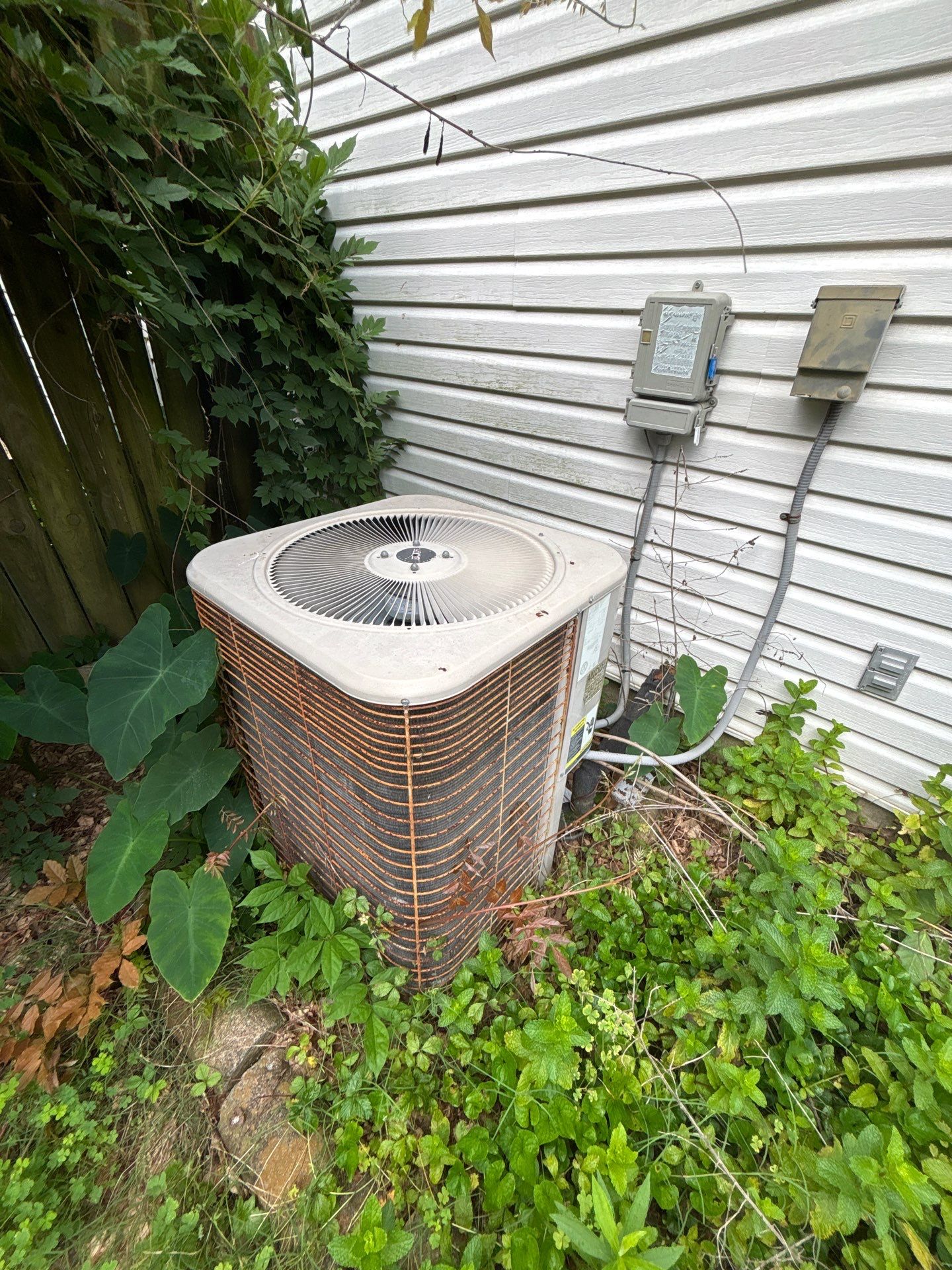 Aging outdoor AC condenser unit at a Bryant, AR home, diagnosed by Paschal's Little Rock HVAC technician