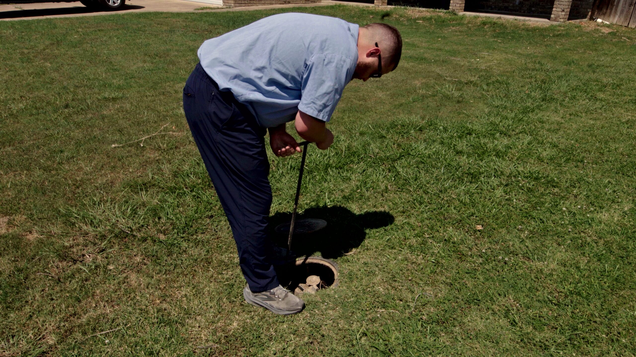 Paschal technician using a water meter key to isolate the water supply at the meter during leak detection in Bentonville